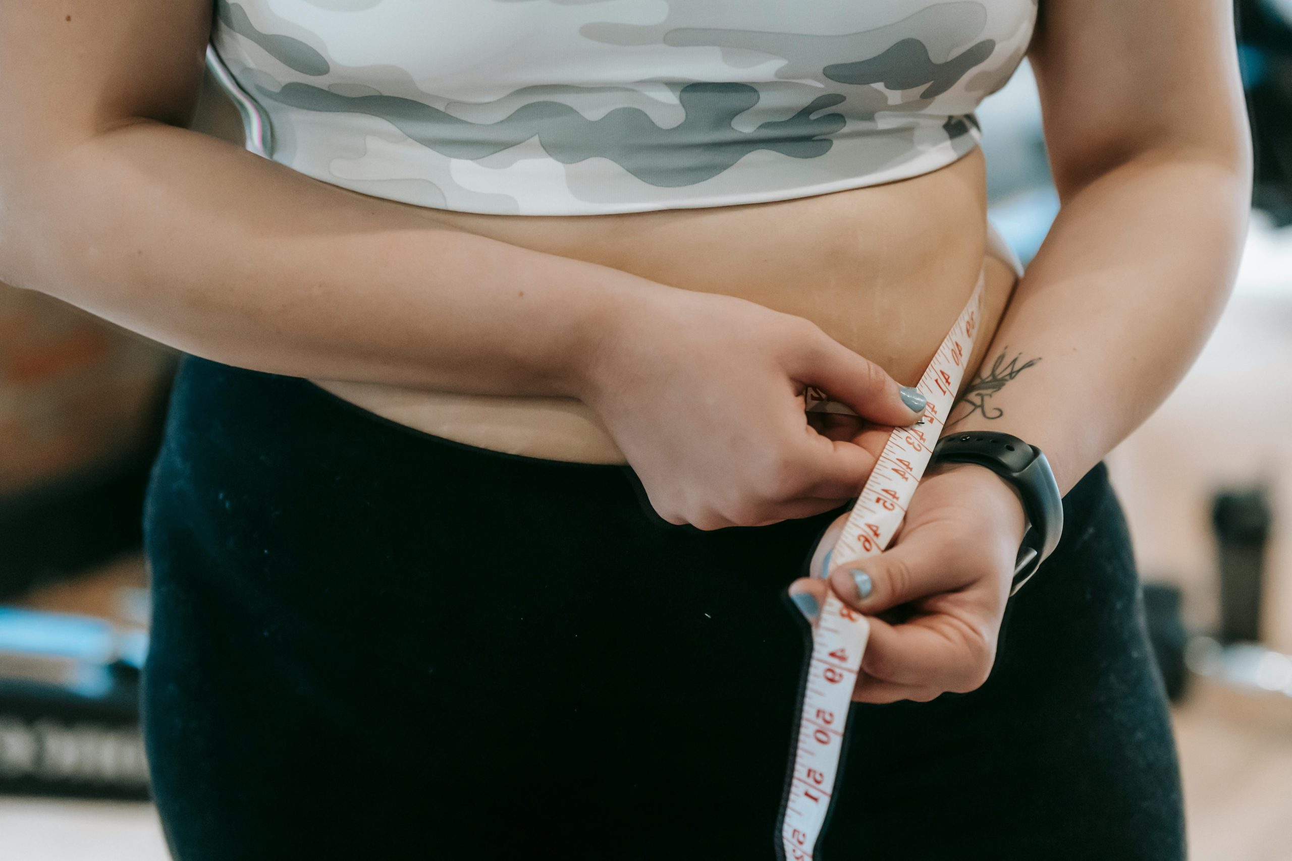 Person measuring their waistline