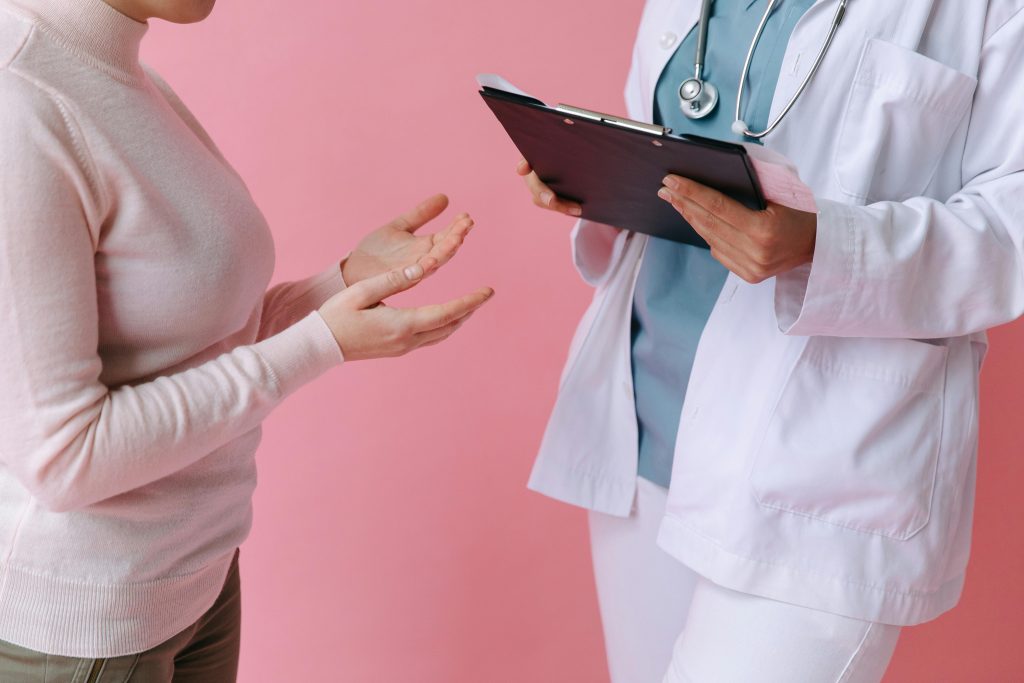 Patient talking to doctor with a pink background