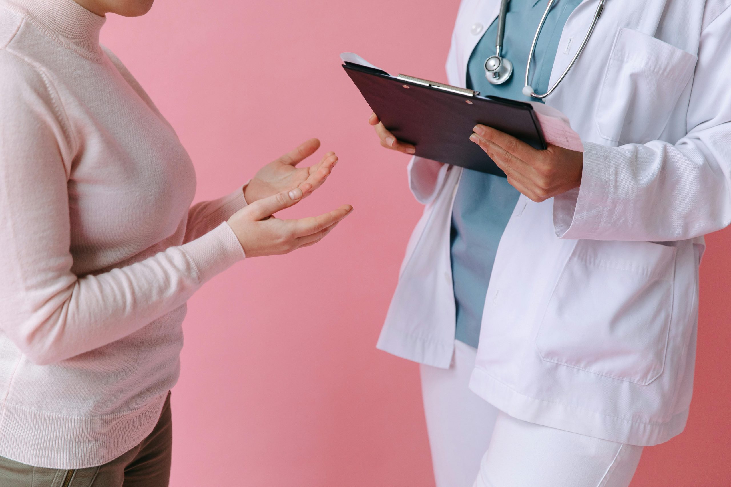 Patient talking to doctor with a pink background