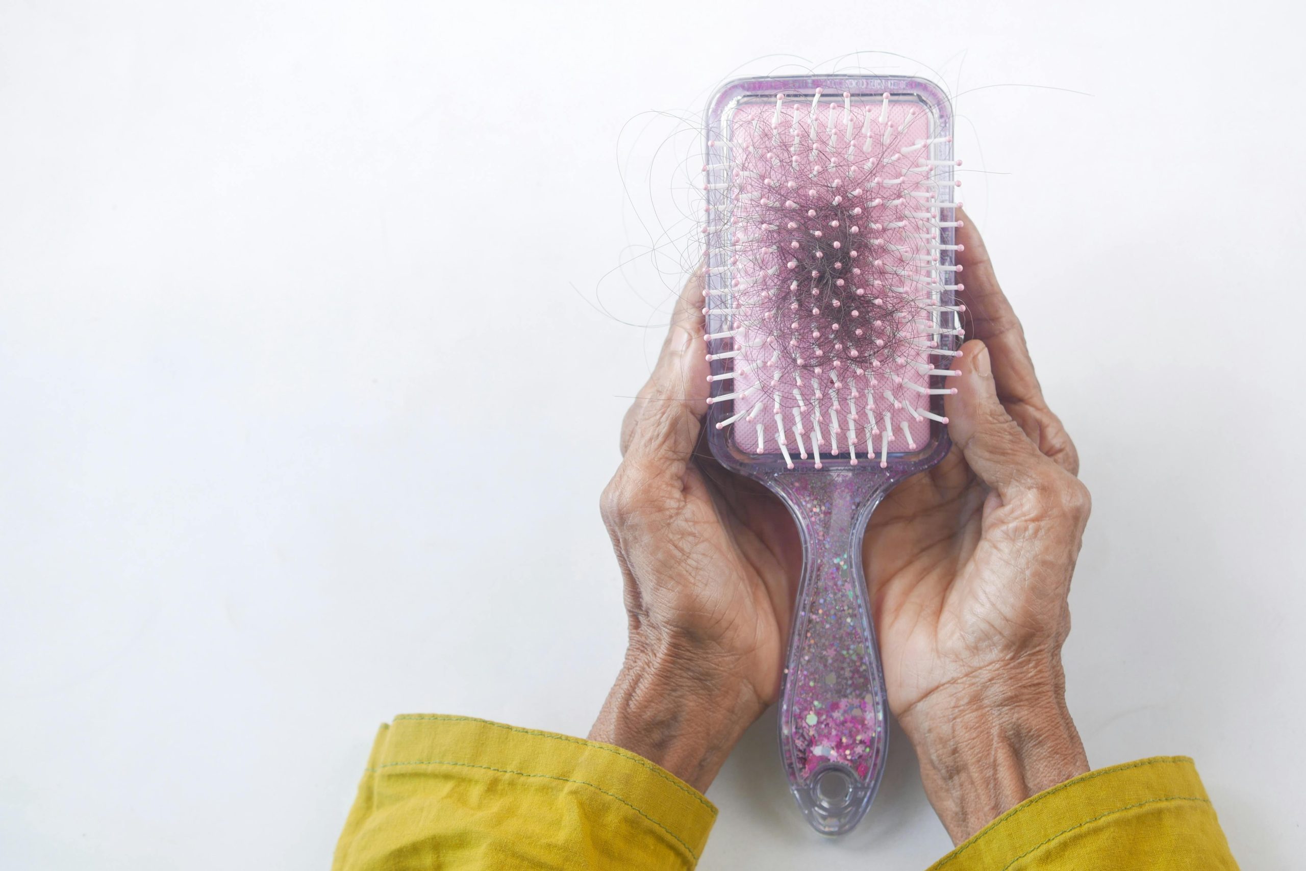 Woman holding a brush with hair in it